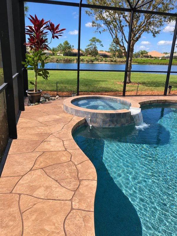 Uro Stone deck in a warm tan flagstone pattern beside a pool and raised spa